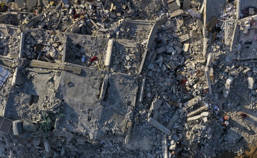 Rescue workers continue to clear rubble from collapsed houses in Sarmada, Syria, on the border crossing with Turkey, on Sunday.