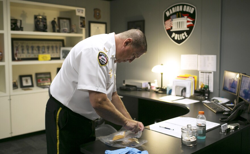 Police Chief Bill Collins inspects confiscated crack cocaine and brown powder heroin in Marion.