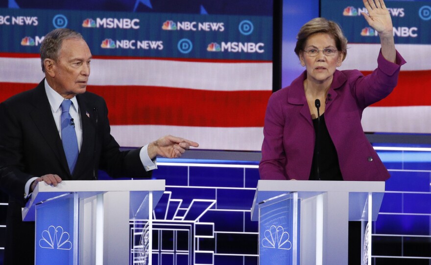 Sen. Elizabeth Warren, D-Mass., gestures during the debate as former New York City Mayor Michael Bloomberg looks on.