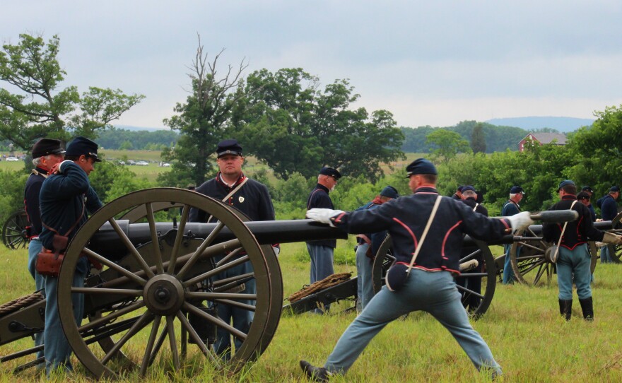 Union re-enactors prime cannons with black powder for a demonstration of artillery fire as part of the Gettysburg National Military Park's commemoration.