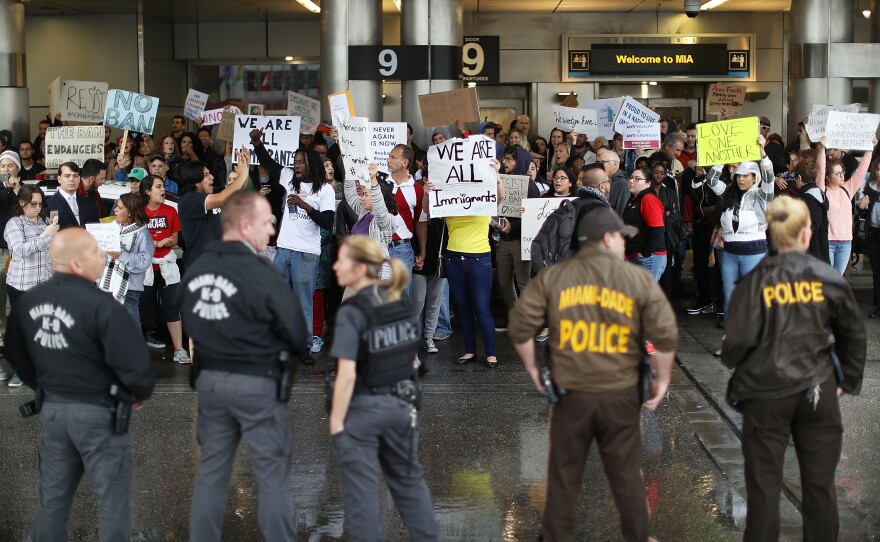 Protesters at the Miami International Airport rally against the president's executive order regarding immigration.