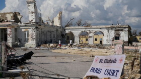 People walk past damage from Hurricane Melissa in Black River, Jamaica on Thursday, Oct. 30, 2025. Federal forecasters predict 8 to 14 named storms, including tropical storms and hurricanes, will form in the Atlantic in 2026.