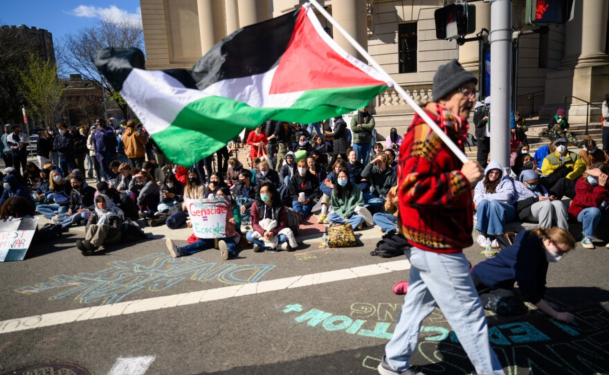 New Haven activist Norm Clement walks with a Palestinian flag in front of hundreds of Yale students, who shut down an intersection in downtown New Haven on April 22, 2024 after police cleared an encampment and arrested 45 students outside the Beinecke library.