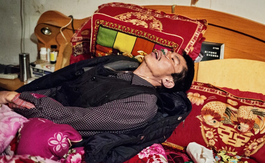 He Quangui, moments after he tried to suffocate himself while the rest of the household was asleep. His wife pulled toilet paper out of his nose, a plastic bag out of his mouth and untied his hands which he bound tightly with white cloth. He Quangui had pulled his oxygen tube off and muttered a prayer to the Chinese gods to take him quickly, to the other world.