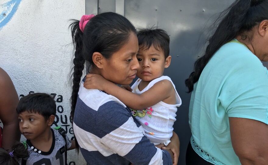 An asylum seeking mother holds her child in Tijuana, April 25, 2018.