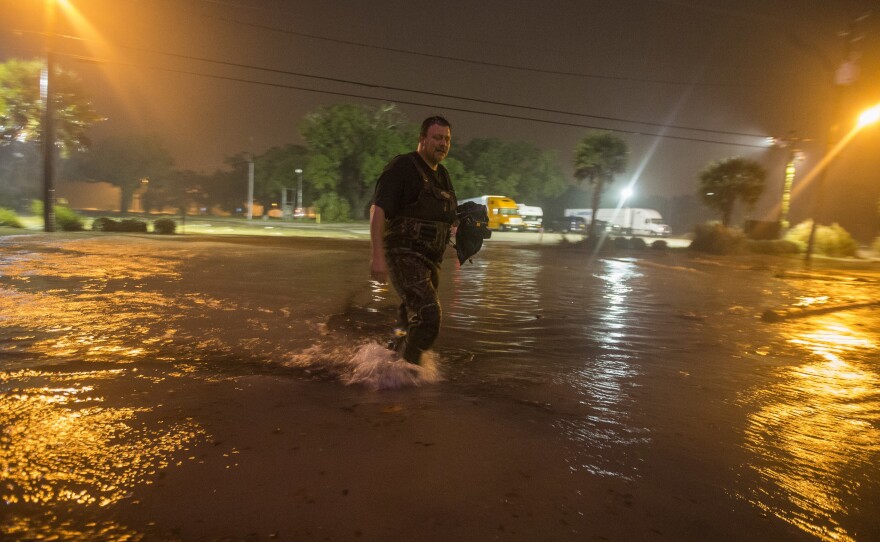 Lanny Dean takes video as he wades along a flooded Beach Boulevard next to Harrah's Casino as the eye of Nate pushes ashore in Biloxi, Miss., early Sunday.