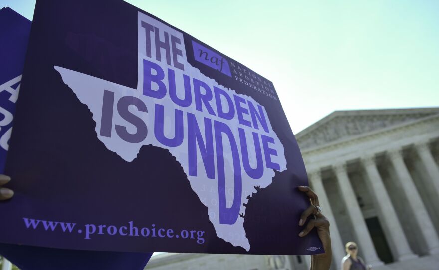An abortion rights activist holds a sign outside the U.S. Supreme Court earlier this year before the court struck down a Texas law placing restrictions on abortions. Now abortion rights supporters are suing the state again over a new rule.