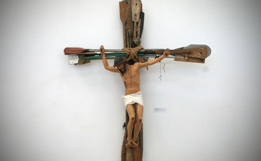 "Miracle," a work by KCho that hangs in his studio, shows Jesus crucified on a cross made of oars.