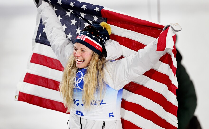 Bronze medalist Jessie Diggins of Team USA celebrates with a flag during the Women's Cross-Country Sprint Free Final flower ceremony on Day 4 of the Beijing 2022 Winter Olympic Games in Zhangjiakou, China.