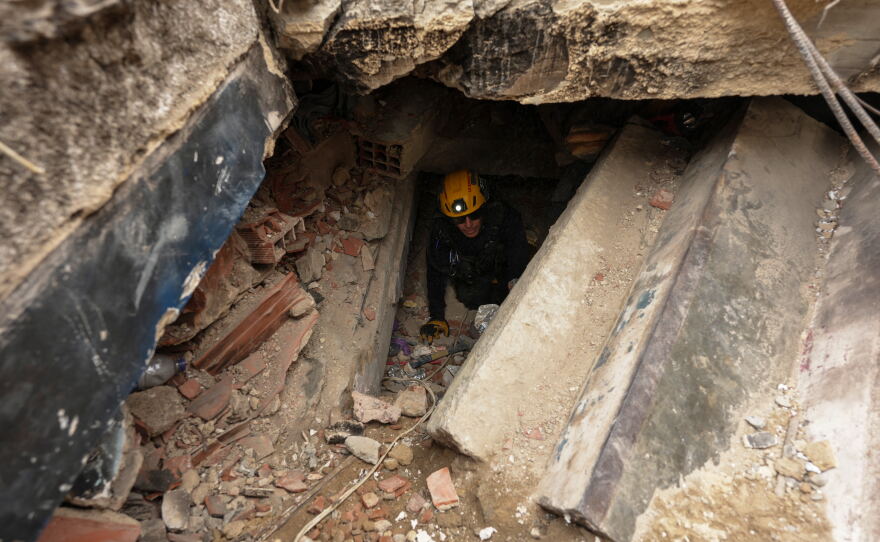 A member of the Los Angeles County Fire Department moves through the rubble of a building that collapsed from earthquakes in La Guaira, Venezuela, Tuesday.