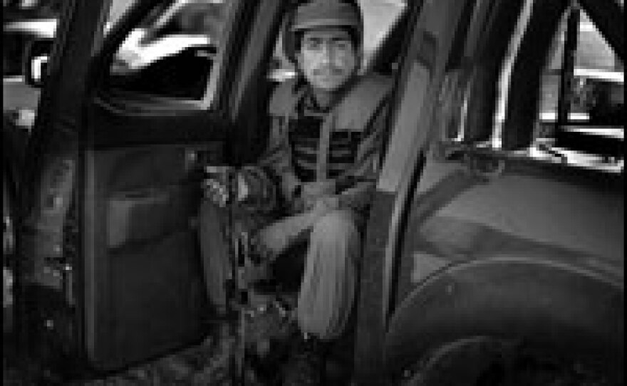 An Afghan policeman sits in the back seat of his truck in Lashkar Gah, capital of Helmand province. Members of the Afghan National Police are four times more likely than Afghan army soldiers to be killed in the line of duty  because they are on the front lines in their communities every day.