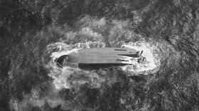 A U.S. Coast Guard HC-130 Hercules airplane crew assigned to Coast Guard Air Station Barbers Point flies over an overturned vessel offshore Saipan, Saturday, April 18, 2026, while searching for a missing vessel, the Mariana, that experienced an engine failure April 15.