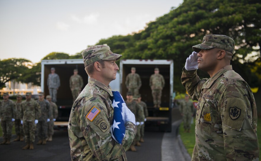 Military honor guards ceremonially escort the remains to trucks for the short trip to the lab to be processed.