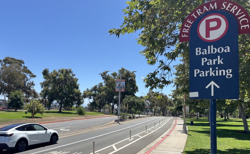 A car drives past a sign directing traffic to Balboa Park's parking lots and free tram service, July 28, 2025.