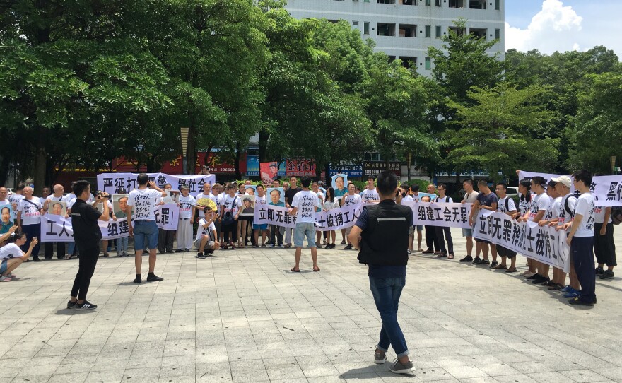 People hold banners at a demonstration in support of Jasic Technology factory workers, outside Yanziling police station in Pingshan district, Shenzhen, Guangdong province, China, on Aug. 6, 2018.