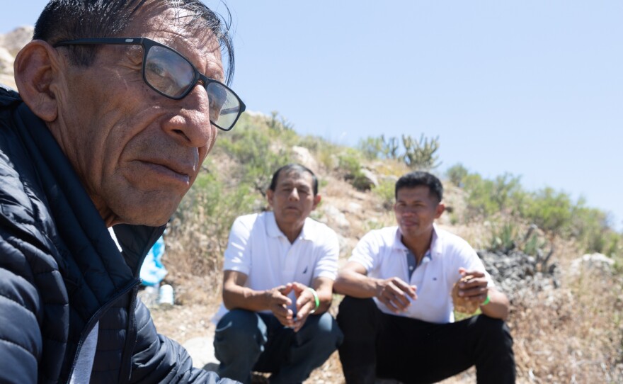 A group of men from Peru wait to be processed by Customs and Border Patrol in the Jacumba Wilderness on May 12, 2023. Hundreds have been in the area for days with little food and water and no shelter.