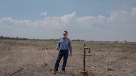 Dan Arthur, the president and chief engineer of ALL Consulting, stands beside a defunct oil well in the Tallgrass Prairie Preserve in Oklahoma on March 20, 2024. The well has not been used for years — there's no pump attached to it. But it hasn't been properly plugged, either.