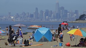 In this May 26, 2020, file photo, people congregate on Robert W. Crown Memorial State Beach with the San Francisco skyline as a backdrop in Alameda, Calif. 