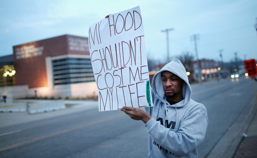 A demonstrator protests in front of the police station in Ferguson, Mo., on Thursday.