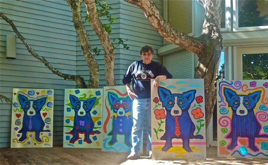 Artist George Rodrigue poses with some of his Cajun heritage paintings.