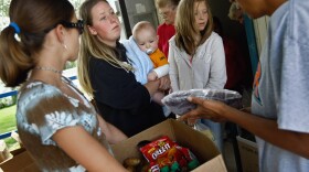 Ashley Shannon and her son Quinton Pilling, 7 months, receive a box of food aid delivered by the Care and Share food bank in the rural town of Hugo, in eastern Colorado.