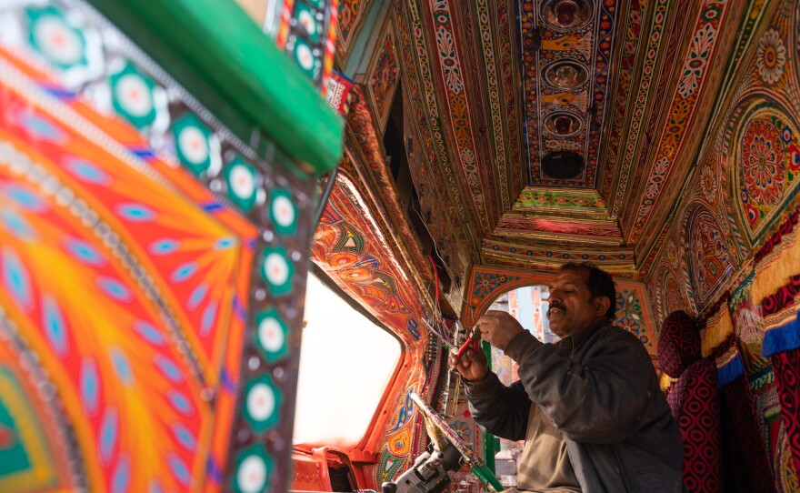 Electrician Muhammad Ishaq, 50, works on a series of lights for the front of a truck.