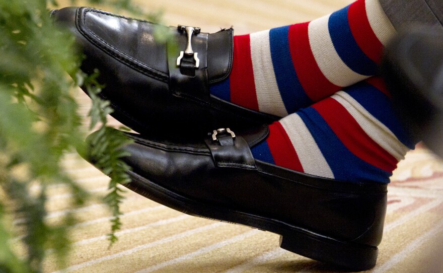 Former President George H.W. Bush crosses his colorfully socked feet during the unveiling ceremony of portraits of his son former President George W. Bush and former first lady Laura Bush, in 2012.