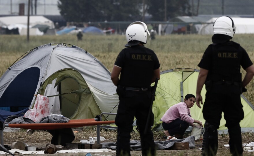 Police officers patrol among tents during evacuation operations Tuesday at the Idomeni camp near the Greek-Macedonian border.