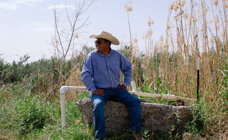 Joe Pineda, 52, sits by the banks of the Rio Grande. He pulls in water from the river to grow alfalfa, pecan trees and other crops. He also runs cattle on his family land, but he says he isn't doing that this year because he's worried about the wall.