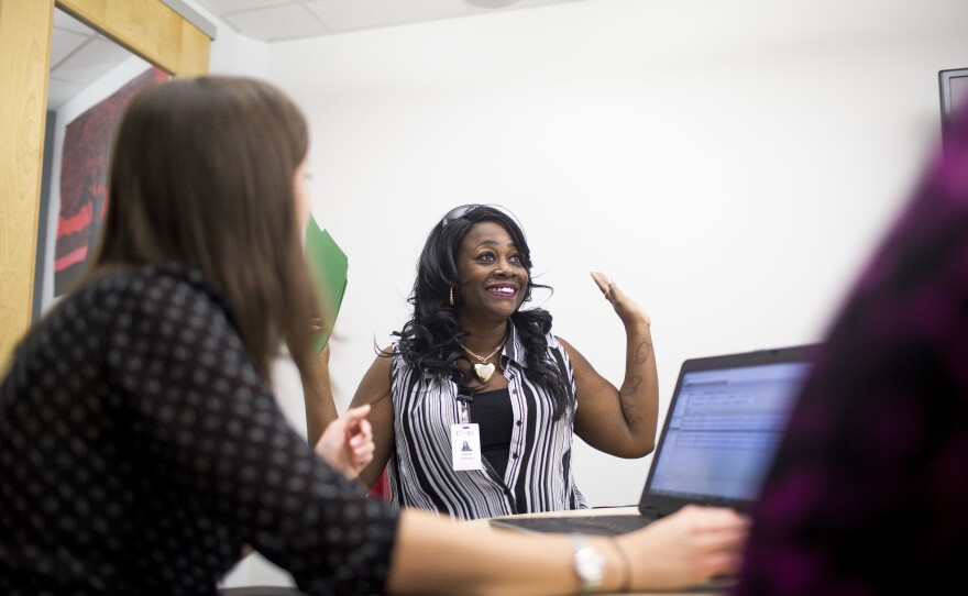 Katina Johnson celebrates during a meeting with her Goodwill Central Texas guidance staff to discuss higher education options.