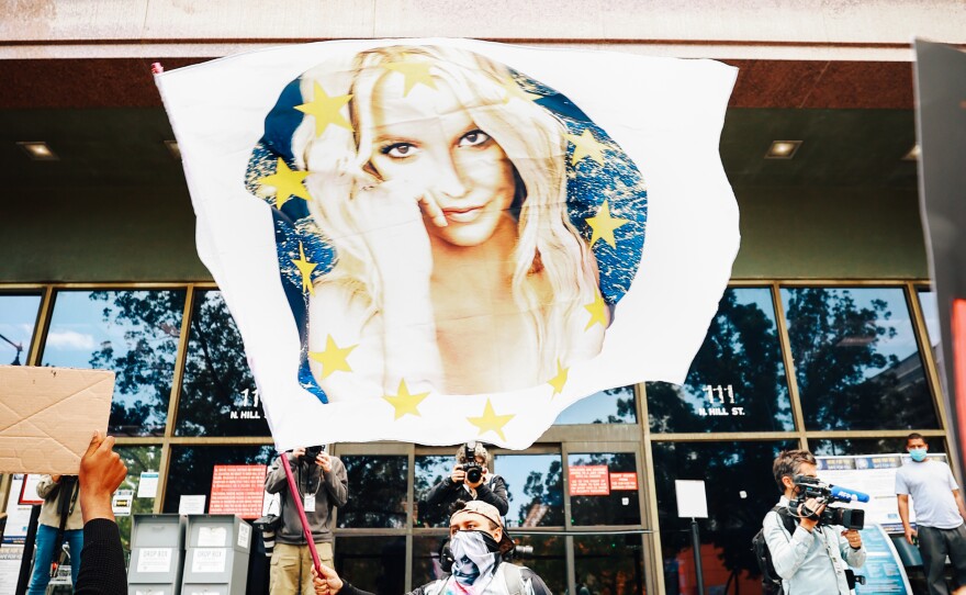 A #FreeBritney protestor flies a Britney flag outside a Los Angeles courthouse. The superstar's conservatorship case has another hearing July 14.