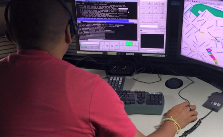 A police dispatcher sits at his desk in this undated photo.