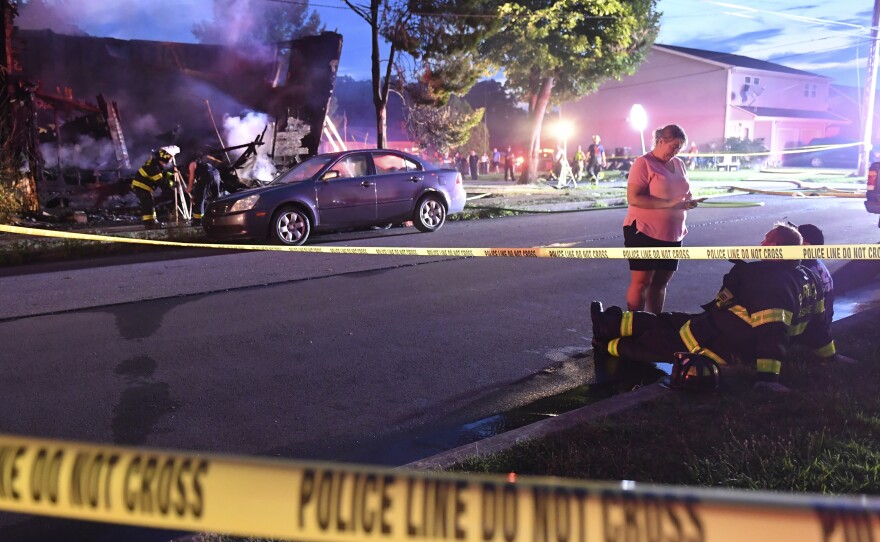 Firefighters on Friday set up lights in front of a fatal house fire in Nescopeck, Pa., that killed 10 people.