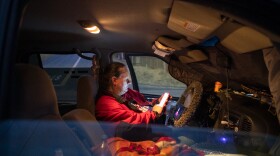 Naomi Flynn watches a movie from inside her SUV along a road in Spring Valley on June 7, 2021. She has been living in her SUV since she was forced to leave a San Diego County-run hotel for COVID-19 isolation.