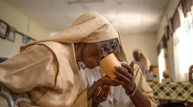 Sister Mary Consolata Nakawooja assists an elderly nun as she takes tea at the Little Sisters of St. Francis premises in Nkokonjeru, Uganda.