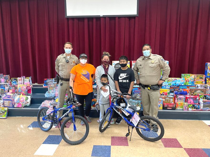 California Highway Patrol officers are pictured with a family and National City mayor Alejandra Sotelo-Solis at a toy giveaway on January 6, 2022.