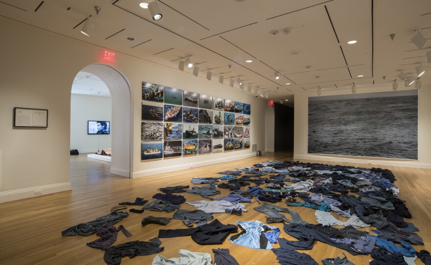 Kader Attia strews second-hand clothing on the floor for the installation <em>La Mer Morte (The Dead Sea).</em>