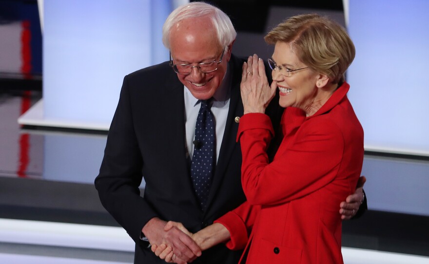 Sens. Bernie Sanders of Vermont and Elizabeth Warren of Massachusetts greet each other at the start of the Democratic presidential debate in Detroit in July.