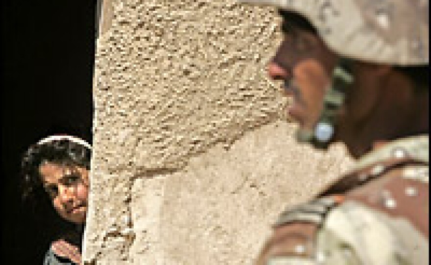 An Iraqi girl looks at an Iraqi soldier securing an area in al-Dor, north of Baghdad, on Friday. U.S. and Iraqi forces are in the second day of a vast sweep -- called Operation Swarmer -- to root out insurgents.