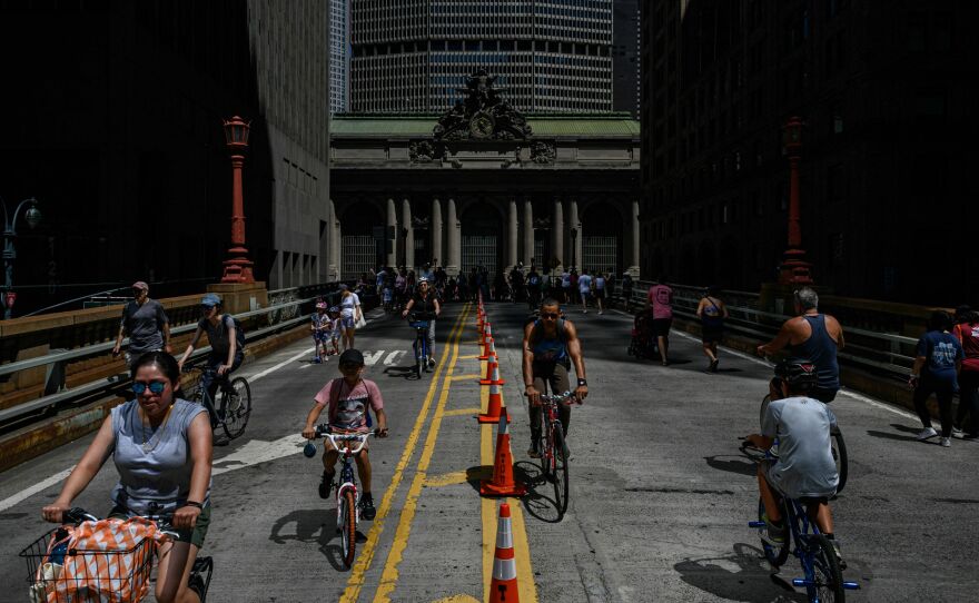 Many cities hope that ditching their parking requirements will make their neighborhoods more amenable to biking and walking. People are seen biking and walking along Park Avenue near Grand Central Station during the Summer Streets initiative in New York City in August 2022.