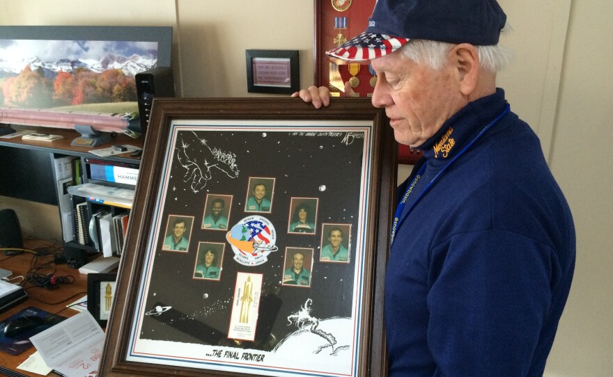 Allan McDonald in 2016 with a commemorative poster honoring the seven astronauts killed aboard the space shuttle Challenger.