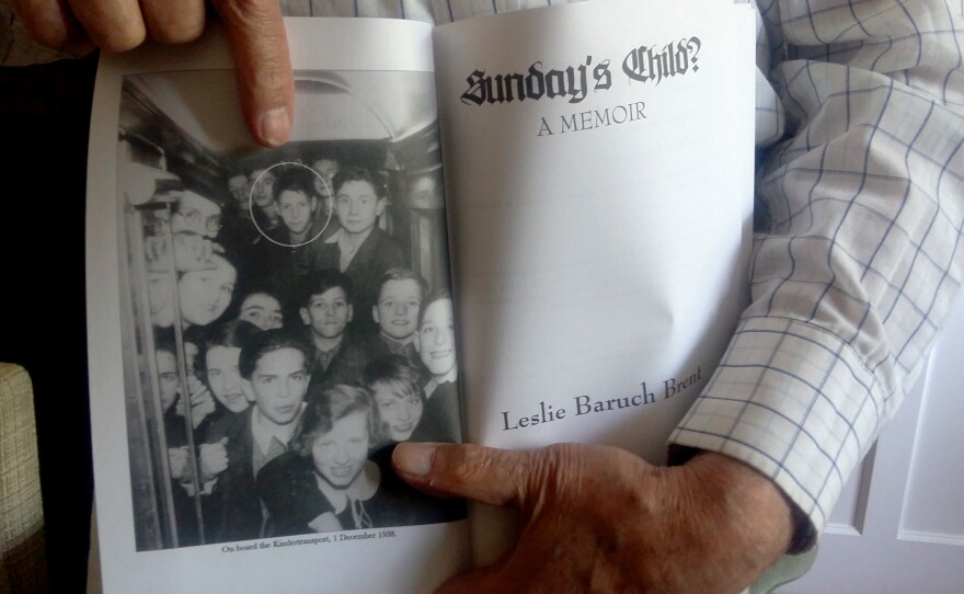 Leslie Brent, 90, a retired immunology professor who came to Britain as a Jewish child refugee via Kindertransport in 1938, holds his autobiography, showing a photo of himself and other Kindertransport children.