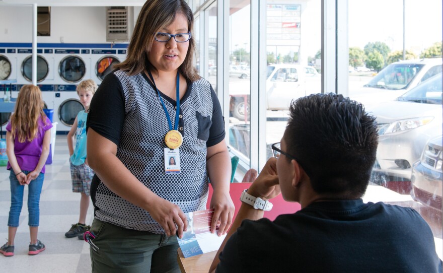 Enrollment counselor Shaina Ramone makes her pitch at a laundromat in Farmington, N.M.