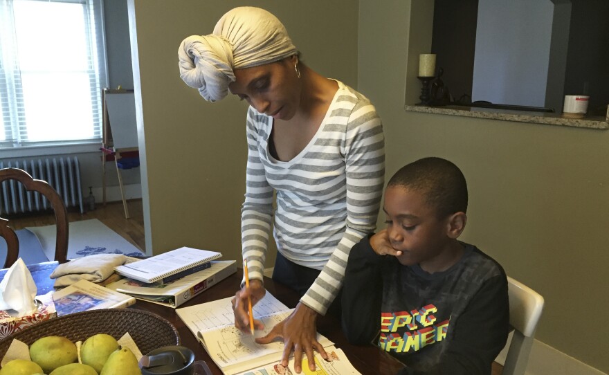 Camille Kirksey helps Brandon with math at the dining room table. Kirksey says black children at Brandon's private pre-K weren't given the kindness she thought they needed, so she decided to home-school him.