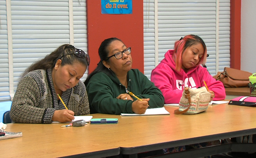 Sofia Herrera, center, sits through a Plaza Comunitaria writing lesson, Dec. 16, 2015.