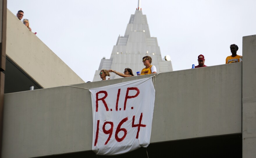 Cleveland fans hang a sign from a parking garage across from the Quicken Loans Arena early Wednesday before the parade.