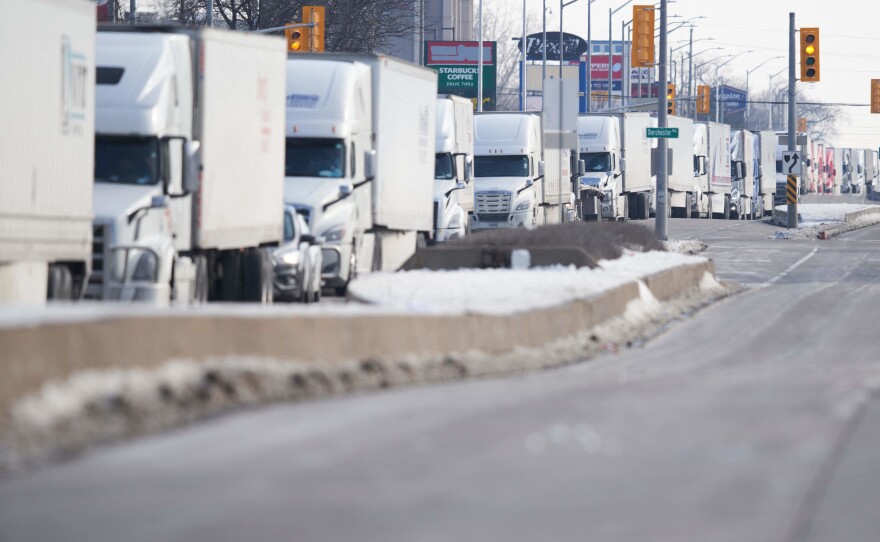 A line of trucks waits for the road to the Ambassador Bridge border crossing in Windsor, Ontario, to reopen February 8  after protesters blocked the road Monday.