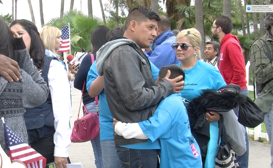 Victor Ledezma is pictured embracing his U.S.-citizen son before applying for humanitarian parole, May 7, 2015.