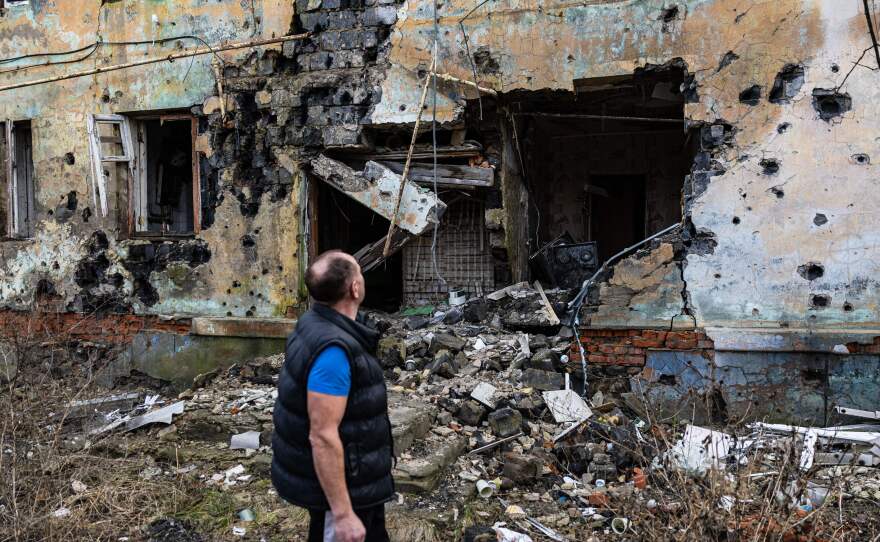Andryi Pleshan checks destruction around his shelter in the city of Izium in eastern Ukraine on Jan. 2.