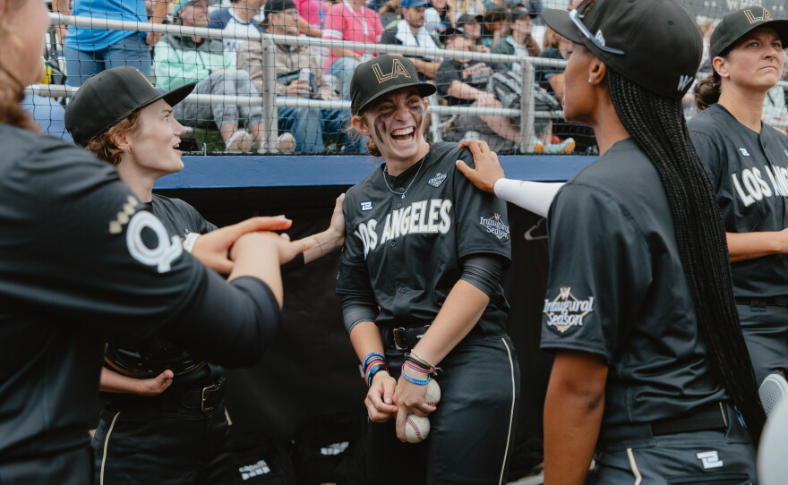 Brittany Apgar (from left), Maggie Foxx and Mo'ne Davis, of the Los Angeles Queens, joke around in the dugout prior to the start of the Women's Pro Baseball League's inaugural game in Springfield, Ill., on Saturday, Aug. 1.